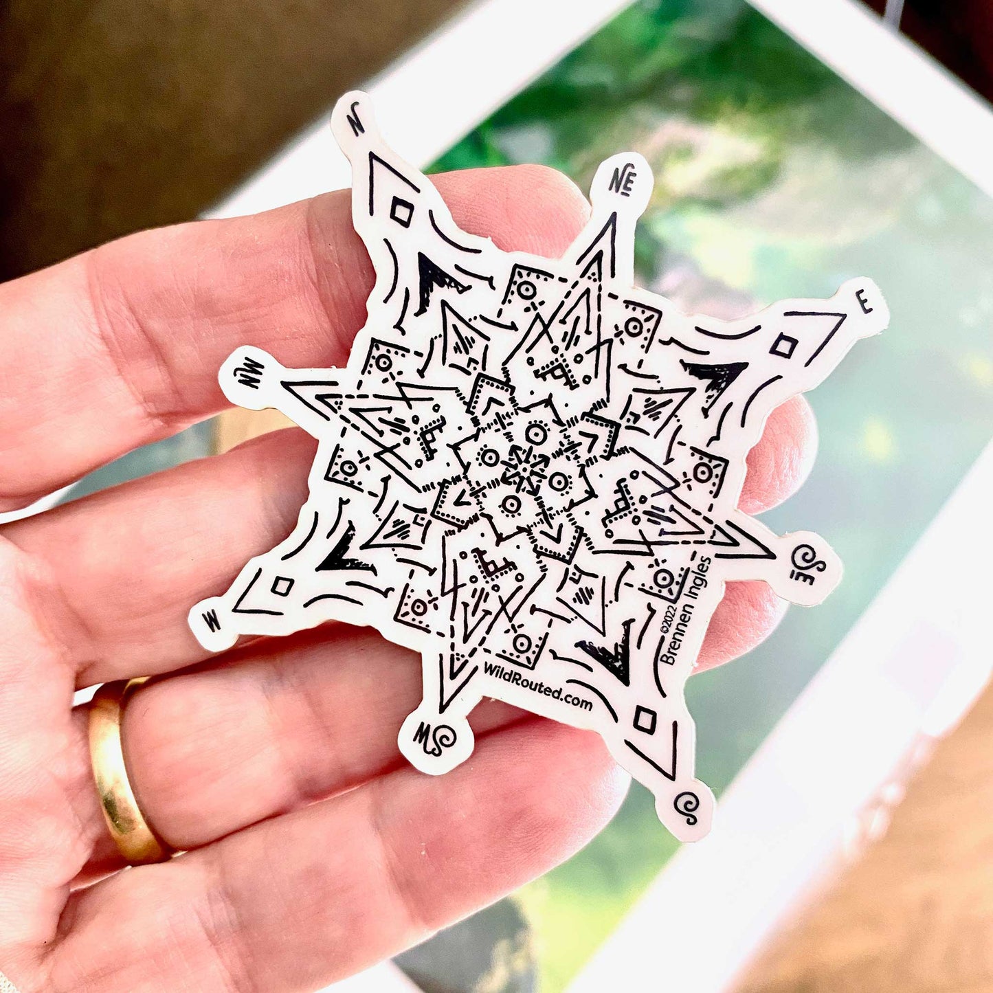 Wild Routed Glow in the Dark Compass Sticker in daylight in hand